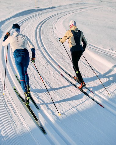 Zwei Skifahrer im klassischen Skilanglauf auf einer schneebedeckten Loipe im Kleinwalsertal, Schwarzwasserloipe, während der Winter-2025-Saison. | © Kleinwalsertal Tourismus eGen • Fotograf: Oliver Farys