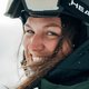 Nahaufnahme einer lachenden Frau mit Skihelm im Schnee, Winteroutfit, bei einem Wintersportshooting. | © Kleinwalsertal Tourismus eGen • Fotograf: Stefan Klauser 