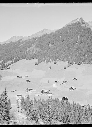 Historisches Schwarz-Weiß-Foto von Baad im Kleinwalsertal, mit Bergen und einzelnen Häusern in der Landschaft. | © Kleinwalsertal Tourismus eGen • Karl Marx Kessler Archiv