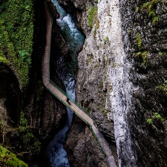 © Kleinwalsertal Tourismus eGen • Breitachklamm • Fotograf: Domink Berchtold Blick vom Zwingsteig in die Breitachklamm im Sommer, enges Tal mit Wasser und Felsen, Umgeben von grüner Vegetation. | © Kleinwalsertal Tourismus eGen • Breitachklamm • Fotograf: Domink Berchtold