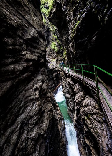 Beeindruckende Ansicht der Breitachklamm mit steilen, felsigen Wänden und einer kleinen Brücke aus Metall. | © Kleinwalsertal Tourismus eGen • Breitachklamm • Fotograf: Dominik Berchtold