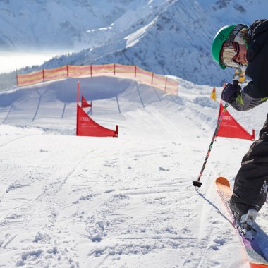Skifahrer auf einer Skipiste in Oberstdorf, mit roten Pylonen und Schnee im Bergpanorama. | © Kleinwalsertal Tourismus eGen • Oberstdorf Kleinwalsertal Bergbahnen