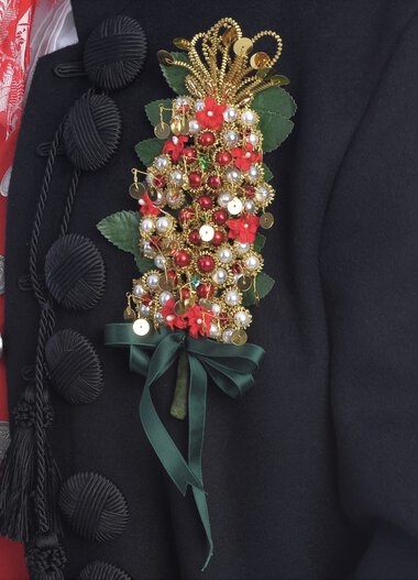 Detail eines traditionellen Trachtenoutfits aus dem Kleinwalsertal mit floraler Brosche und bunten Stickereien. | © Kleinwalsertal Tourismus eGen • Fotograf: Christoffer Leitner