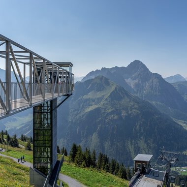 Panoramic view from Walmendingerhorn with mountain scenery in summer, including viewing platform and cable car. | © Kleinwalsertal Tourismus eGen • Photographer: Steffen Berschin