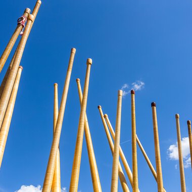Wooden alphorn instruments being assembled outdoors against a blue sky during a festival. | © Kleinwalsertal Tourismus eGen • Photographer: Frank Drechsel