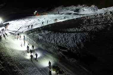 Nachtaufnahme von Skifahrern auf einer Beleuchteten Piste im Kleinwalsertal bei einer Veranstaltung im Winter 2024.