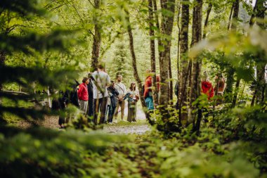 Gruppe von Menschen beim Wandern im grünem Wald, bei Footprint Festival 2024 im Kleinwalsertal.